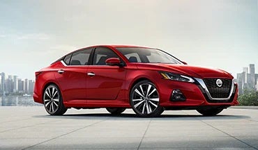 2023 Nissan Altima in red with city in background illustrating last year's 2022 model in Rolling Hills Nissan in Saint Joseph MO